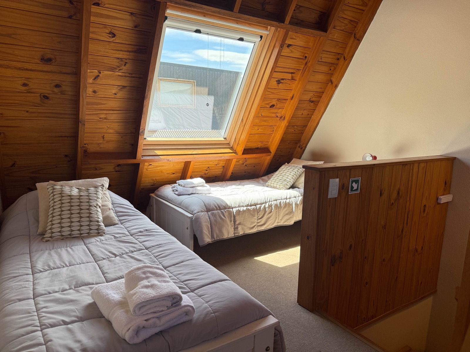 Segundo dormitorio con 2 camas individuales y techo inclinado de madera